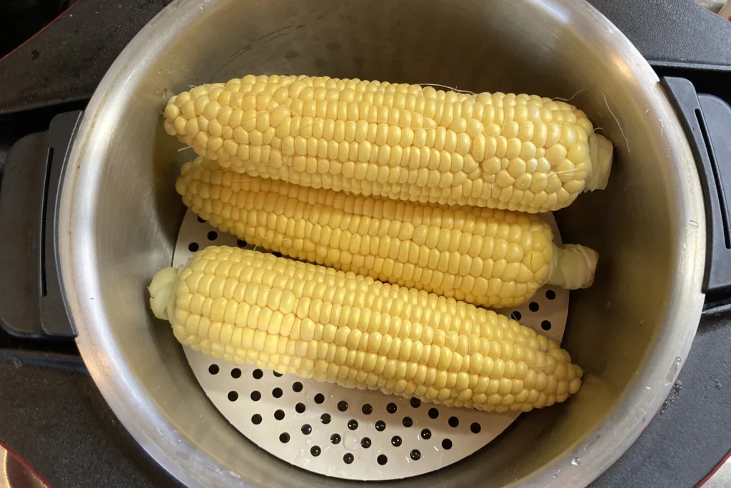 皮をむいたとうもろこしが蒸し器の中に並べられている状態
