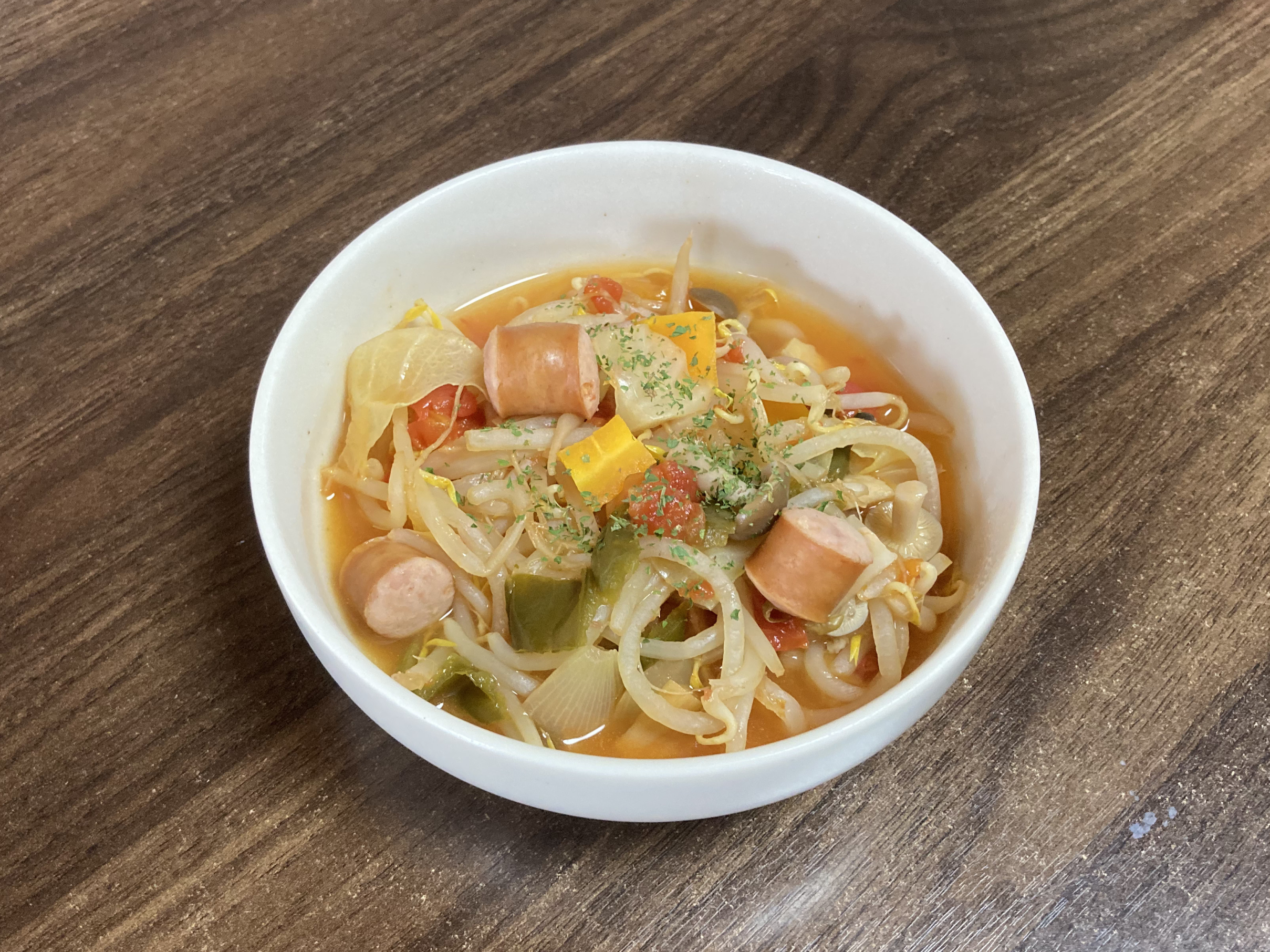 器に盛り付けられたウインナー入り野菜スープ。パセリがトッピングされている