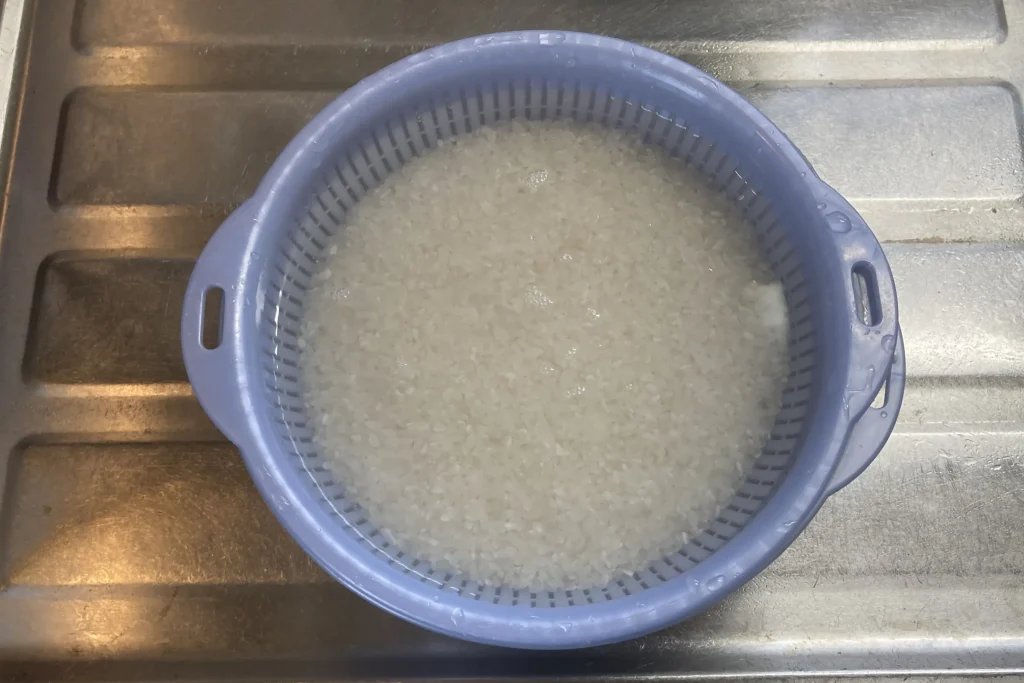 ボウルに入った米を水で研いでいる様子