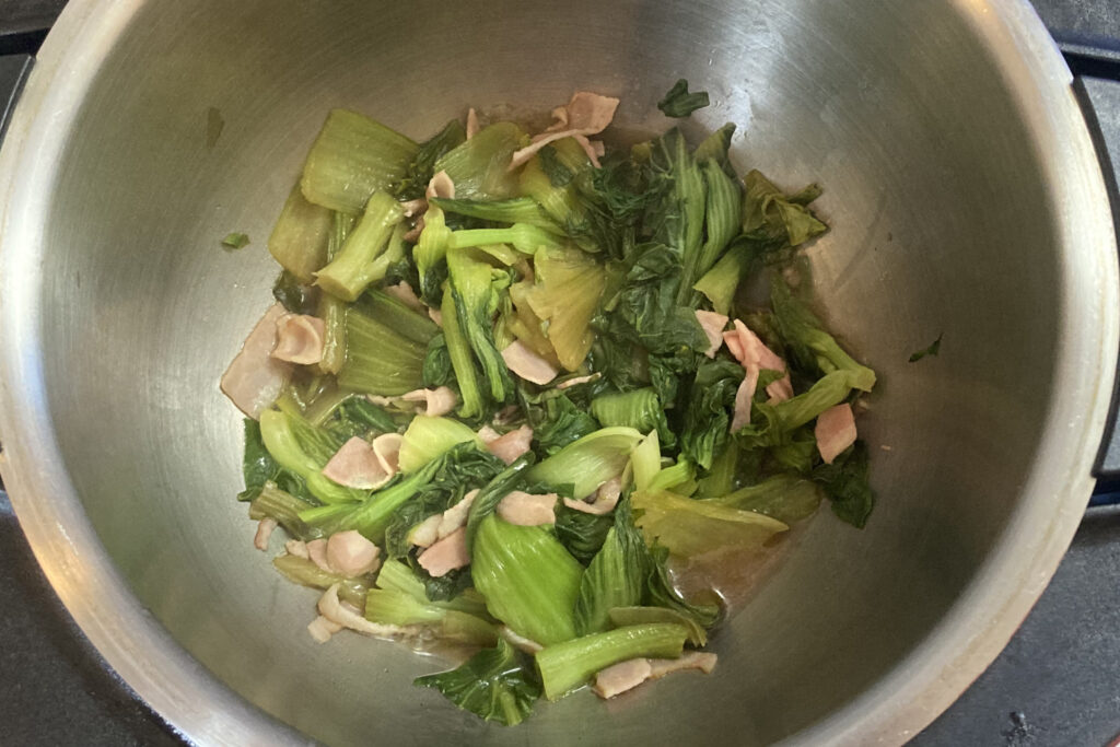 ホットクック内鍋で2分加熱して完成したチンゲン菜とベーコンのウスターソース炒め。チンゲン菜がしんなりと火が通り深い緑色に変化している