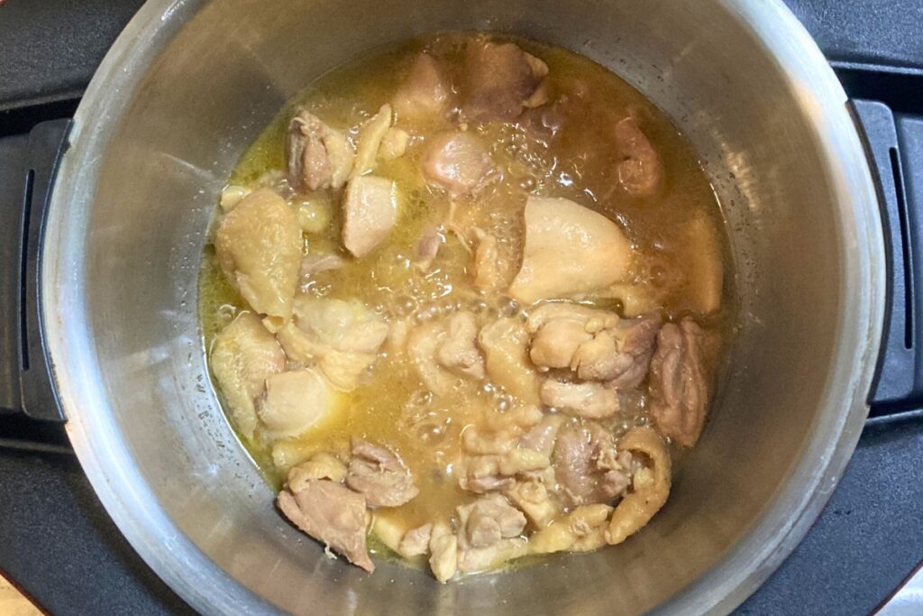 炒め機能での10分間の加熱が完了し、ホットクックの蓋を開けた直後の様子。鶏肉から出た旨み水分とバター醤油がしっかりと絡み合い、食欲をそそる湯気と照りが確認できます。