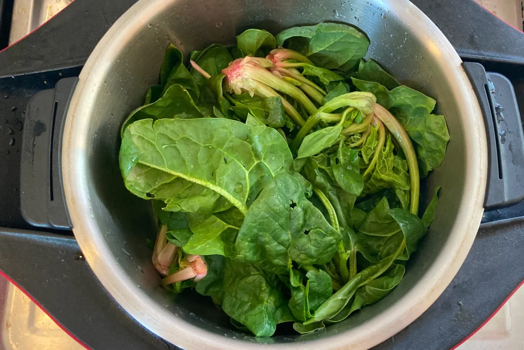 茹でる前の下準備として、内鍋の中にたっぷりといれられた大きな葉のほうれん草。