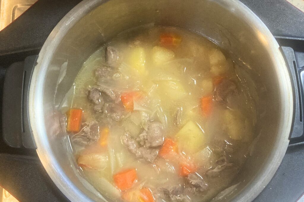 自動調理鍋で具材を煮込んだ直後の様子。カレールーを加える前の段階で、豚肉、じゃがいも、にんじん、玉ねぎがたっぷりの水分とともに柔らかく煮上がっている状態です。