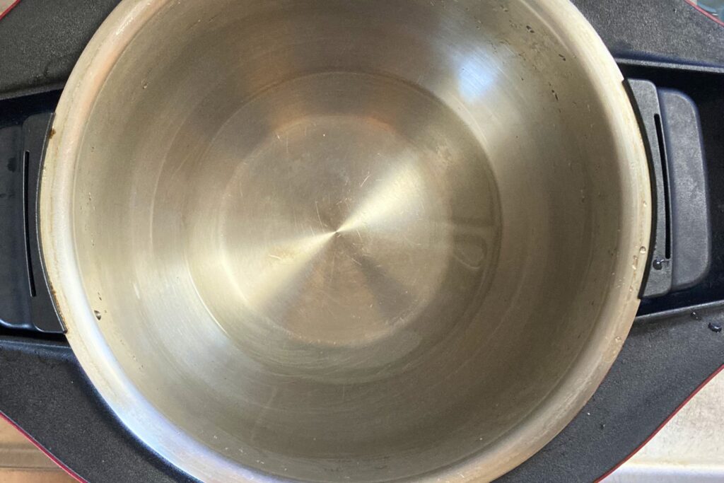 シャープの自動調理鍋ホットクックの清潔なステンレス製内鍋を真上から撮影した写真。調理を開始する前の空の状態。