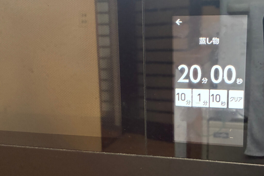 ヘルシオのタッチパネル液晶画面に手動調理の蒸し物メニューと20分00秒の加熱時間が表示されている様子。角皿を上段にセットし水タンクの水位2で調理をスタートする。