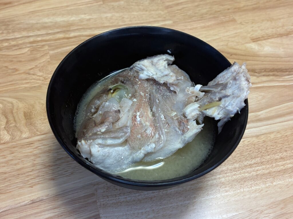 黒いお椀に盛った鯛のあらの味噌汁