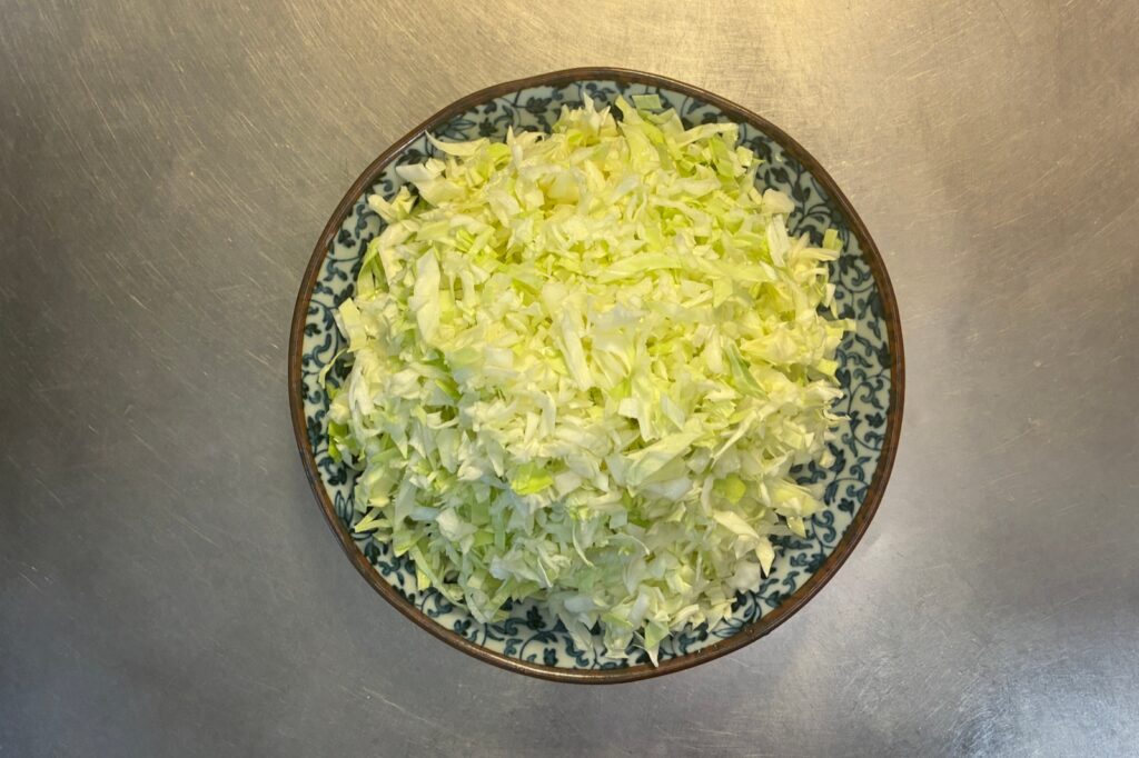 青い模様の器に山盛りにした、粗めに刻んだキャベツ